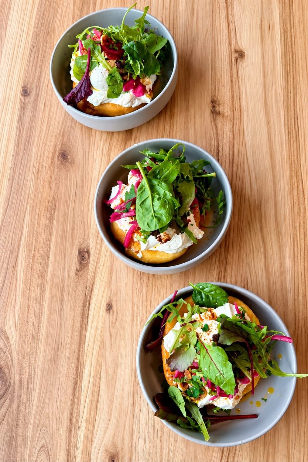 Drei Schalen mit Fladenbrot, Stracciatella, eingelegten Zwiebeln und Blattsalat – Brunch by Sole, Berlin-Schöneberg